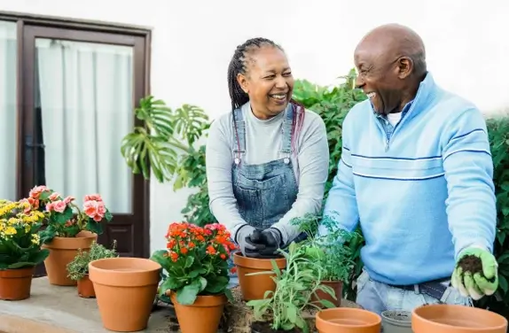 Couple smiling planting pot plants