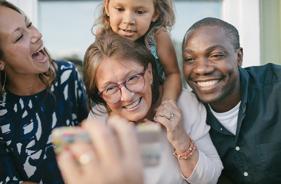 man showing mobile to happy family