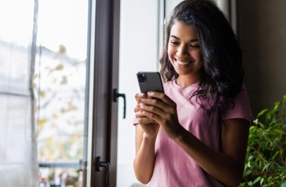 Young woman smiling looking at phone